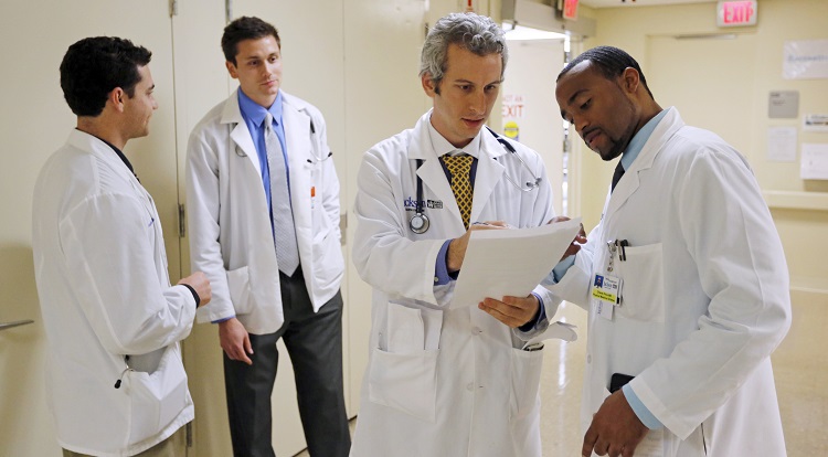 Doctors Jordan Klein and Chane Price confer as University of Miami interns Ignatios Papas and Tim Sterrenberg look on in the Rehabilitation Unit of Jackson Memorial Hospital in Miami